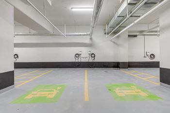 Two parking spaces with green and white signs on the floor.